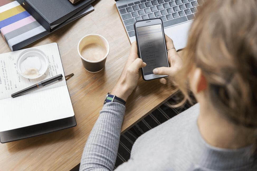 A women at her desk on her cellphone